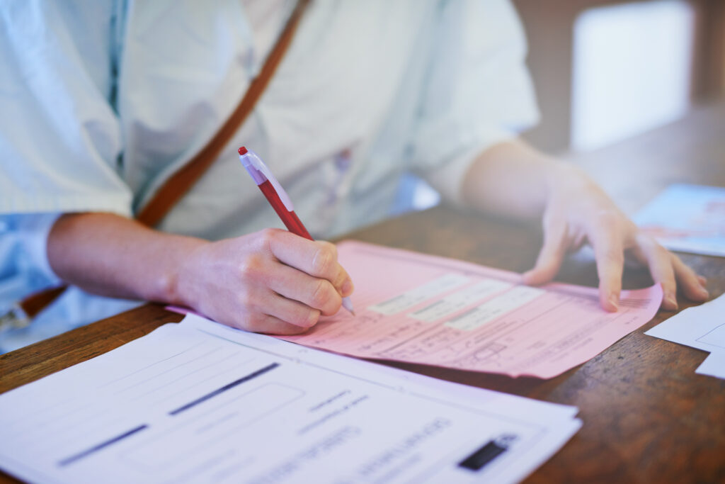 Important patient paperwork. Cropped shot of a doctor filling out paperwork in a hospital.