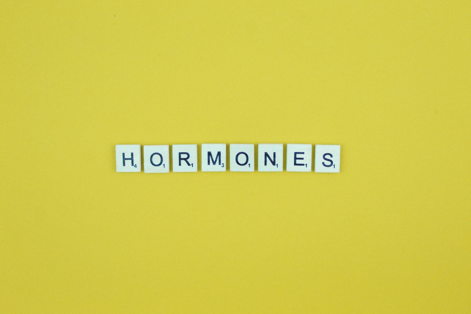 Hormones- scrabble letters word on a yellow background